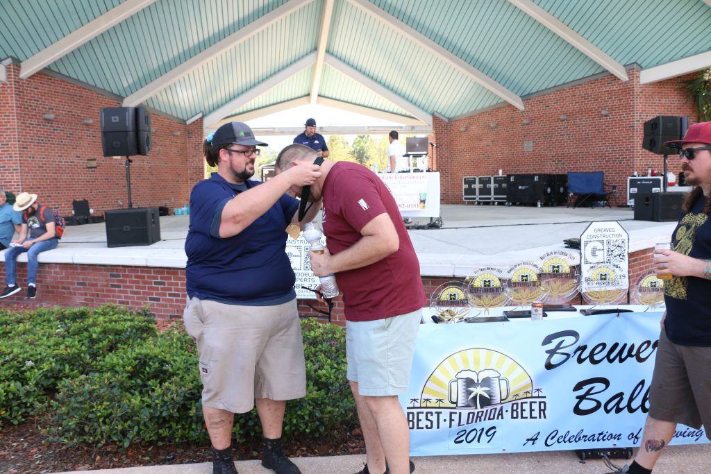 Coppertail Brewing's Casey Hughes accepts a medal at 2019 Brewers Ball Best Florida Beer Competition 