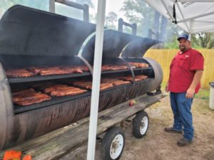Team Cone Sales Manager Kenny Kinsey watches over ribs and Boston butts as they cook