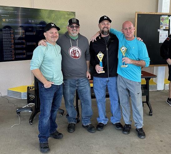 Men standing in a row after winning cornhole