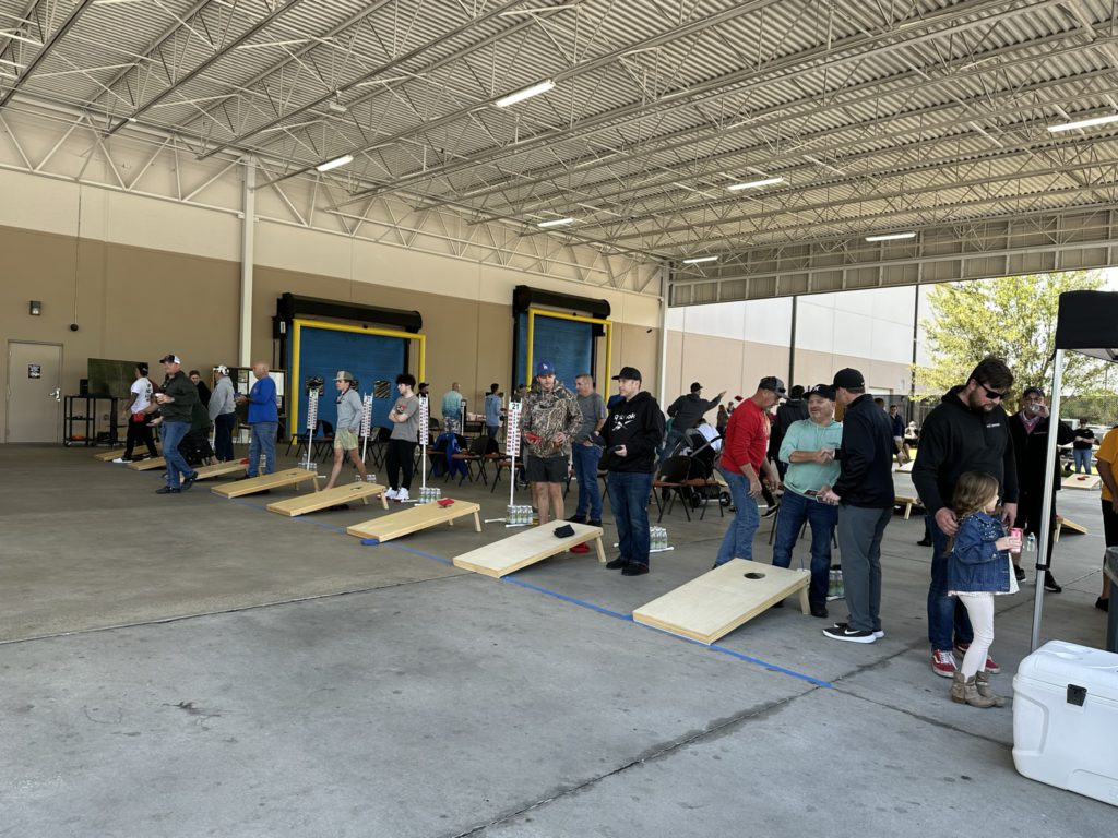 Row of people playing cornhole